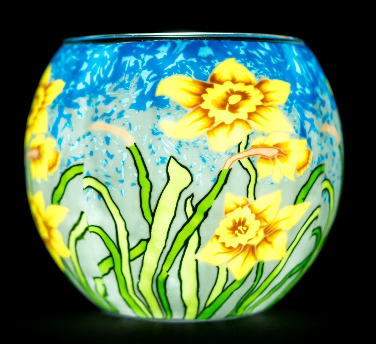 Sunshine Daffodils Claymaster light globe glowing from within, showing yellow daffodils on green stems against a sky-blue background