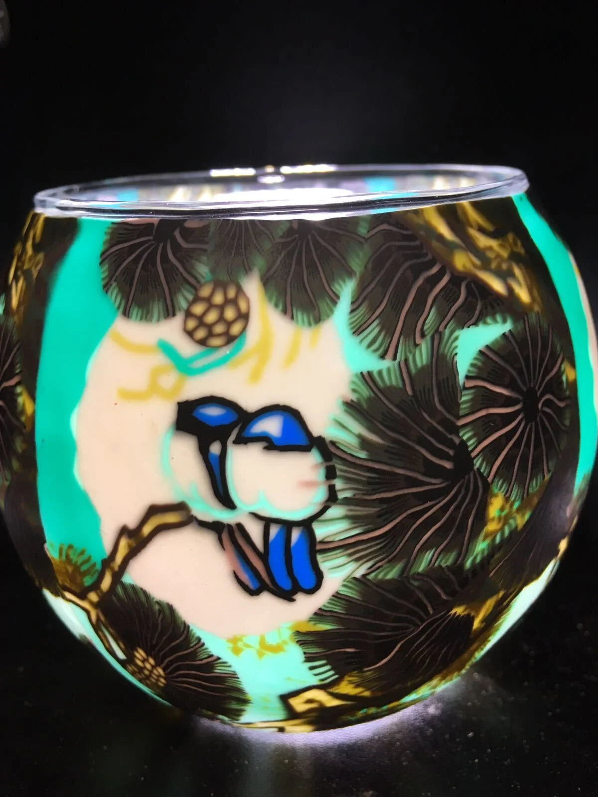 Love Birds Claymaster light globe glowing turquoise with two blue-and-white birds nestled on a golden branch among pine boughs